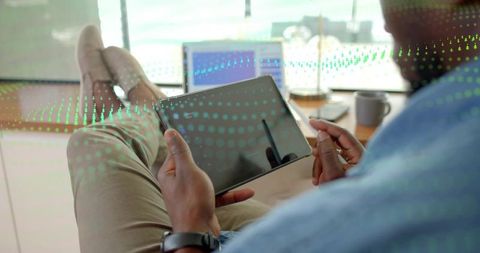 Relaxed office professional using tablet with stylus for data visualization and analytics