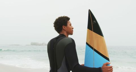 Surfer Gazing at Ocean: Contemplative Beach Moment