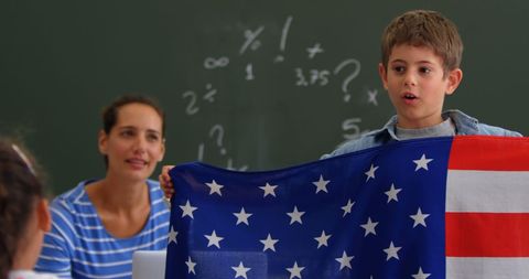 Schoolboy Presenting American Flag in Classroom