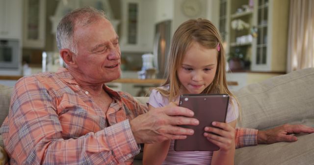 Grandfather and Granddaughter Using Digital Tablet in Living Room - Download Free Stock Images Pikwizard.com