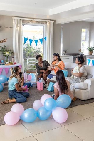 Diverse Friends Celebrating with Babies Amid Pastel Decorations