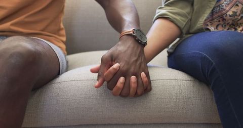 Interracial Couple Holding Hands on Cozy Sofa