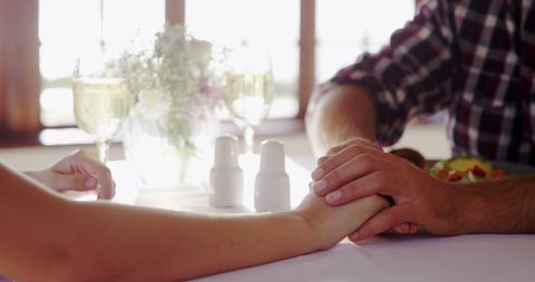 Romantic Couple Holding Hands at Restaurant Table