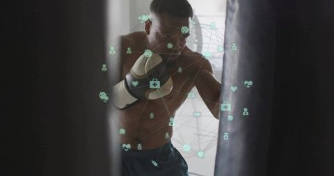 Backlit boxer punching heavy bag while training with digital wellness network overlay