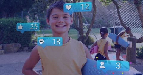 Smiling boy with yoga mat glowing with social media interactions