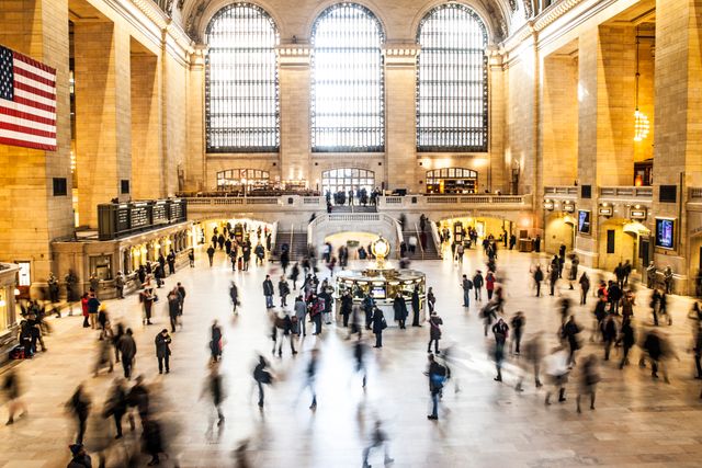 Grand Central Station depicts busy atmosphere with commuters walking, blending modern travel with historical architecture. Use for urban lifestyle scenes, travel, and transportation themed content, or to highlight iconic locations in New York City.
