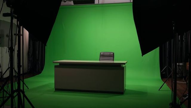Empty news desk on cyc green screen studio with professional lighting, softbox rigging