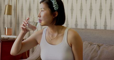 Asian woman drinking water at home in casual morning atmosphere
