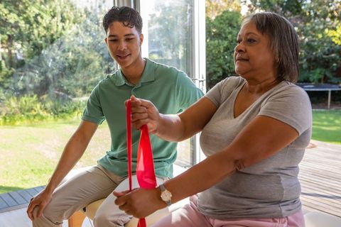 Multiethnic Pair Using Resistance Band for Home Exercise focusing on Wellness
