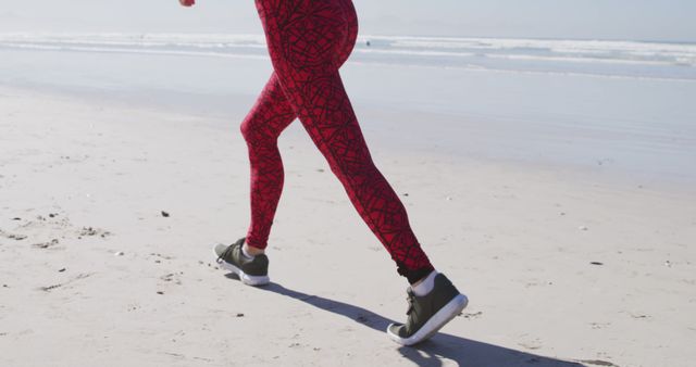 Person enjoys a beach run on a sunny day. Outdoor exercise by the sea promotes a healthy lifestyle and relaxation.
