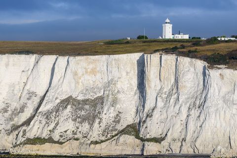 Scenic lighthouse on chalky cliffs overlooking blue sea