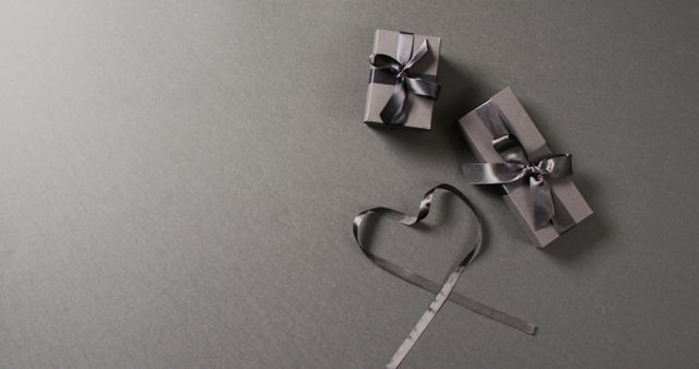 Overhead view of two black gift boxes and ribbon in heart shape, on dark grey with copy space - Download Free Stock Photos Pikwizard.com