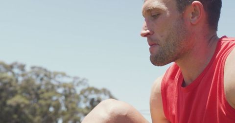 Man tying shoe for outdoor exercise in sunlight