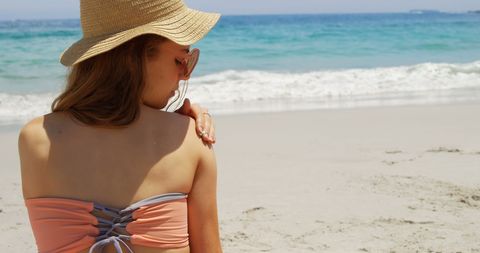Woman Applying Sunscreen Relaxing on Sunny Beach - Download Free Stock Images Pikwizard.com
