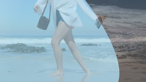 Woman in Cozy Sweater Strolling on Tranquil Beachfront