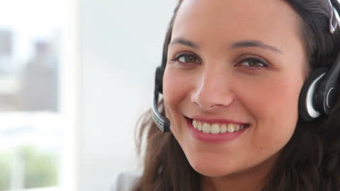 Smiling Businesswoman with Headset in Modern Office