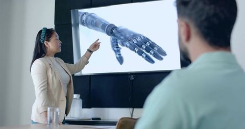 Presenter discussing robotic prosthetic hand design in office