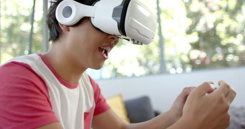 Young Asian Man Immersed in Virtual Reality Gaming at Home