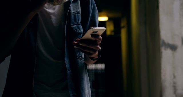 Man using smartphone in dark alley wearing casual outfit - Download Free Stock Images Pikwizard.com