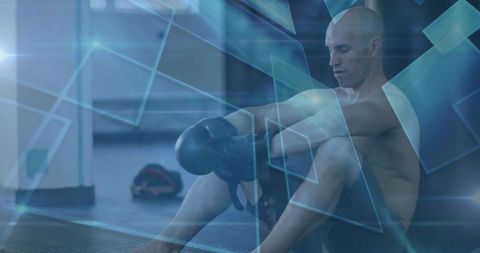 Athlete Adjusting Boxing Gloves with Geometric Overlays in Gym