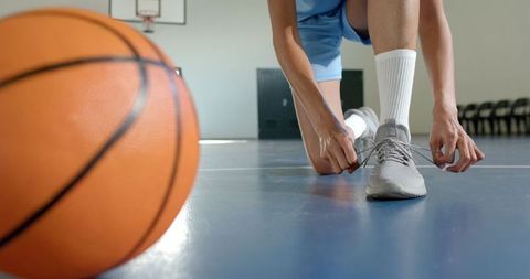 Female Basketball Player Preparing for Game on Indoor Court