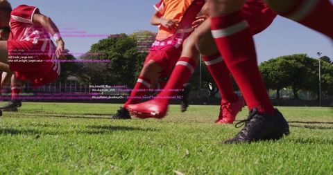 Energetic Young Soccer Players in Mid-Sprint on Green Field