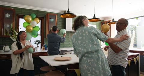 Senior Friends Decorating Home with Balloons for Celebration