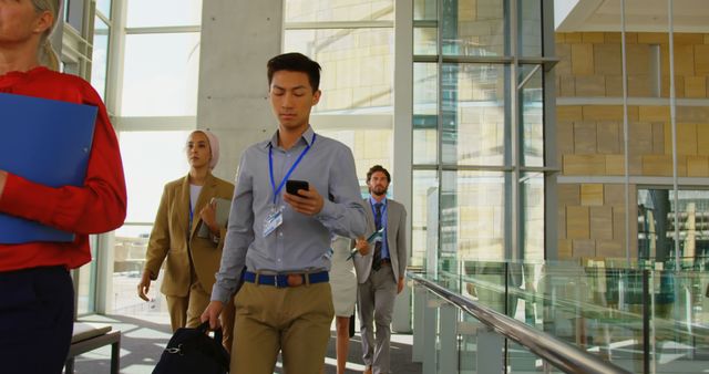 Business Team Walking Down Office Hallway with Documents and Devices - Download Free Stock Images Pikwizard.com