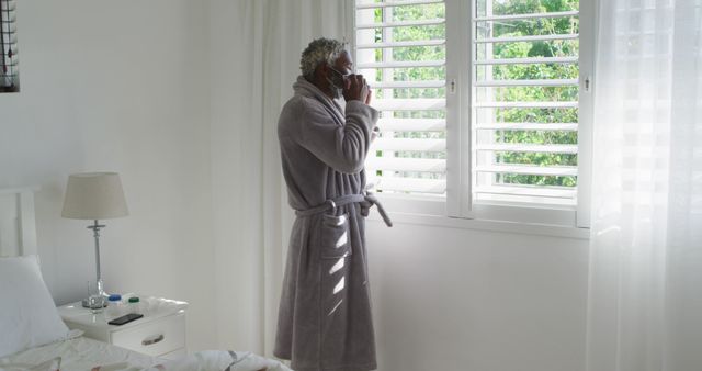 Man in Bathrobe Drinking Coffee by Window in White Bedroom - Download Free Stock Images Pikwizard.com