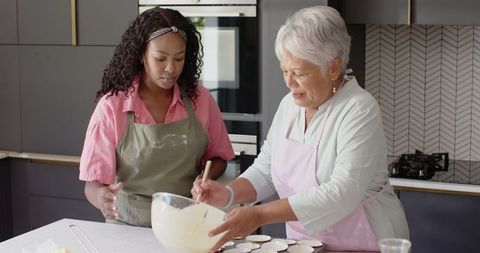 Grandmother and Granddaughter Joyfully Baking Cupcakes Together