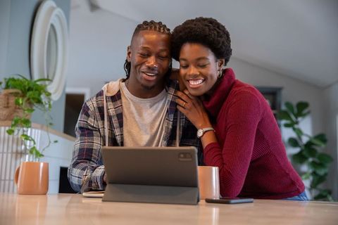Happy Couple Relaxing at Home Viewing Tablet