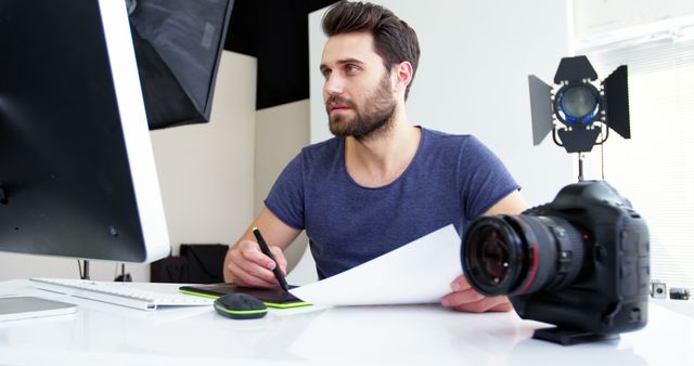 Male Graphic Designer Working at Desk with Digital Tablet and Camera - Download Free Stock Images Pikwizard.com