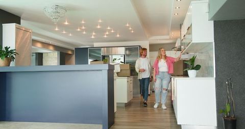 Smiling couple touring modern kitchen of new home