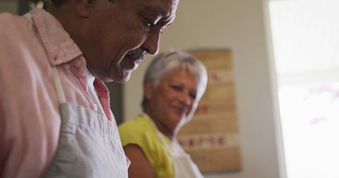 Happy senior couple in kitchen preparing food