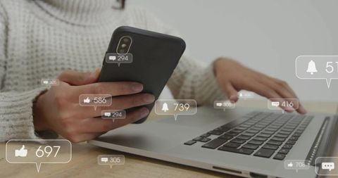 Woman holding smartphone and using laptop with social media notification overlays