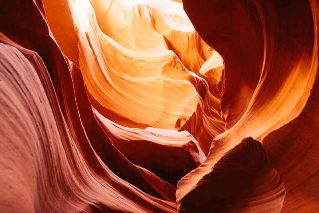 Sunlight brilliantly illuminates the stunning red rock formations of Antelope Canyon, creating an otherworldly atmosphere. This could be used for promoting travel destinations, adventure tourism, nature photography exhibitions, or geological studies.