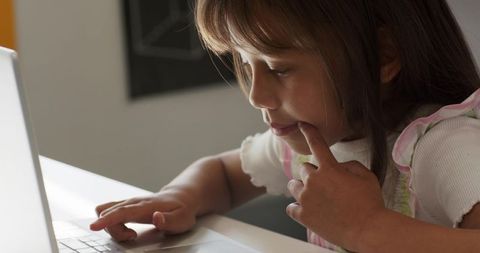 African american girl concentrating on laptop learning online at study desk