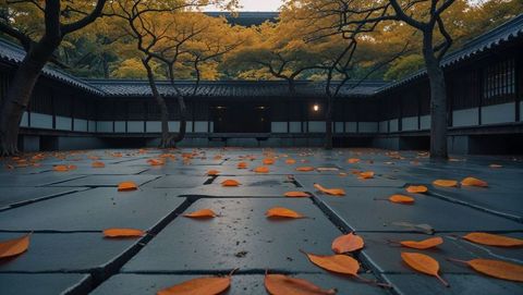 Leaf-strewn stone courtyard in serene temple grounds at dusk