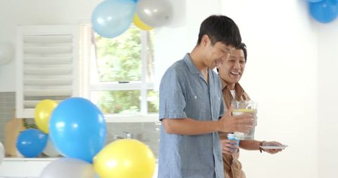 Father and Son Celebrating Together with Kitchen Decorations