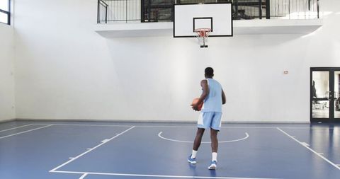 African american athlete preparing shot at indoor basketball court