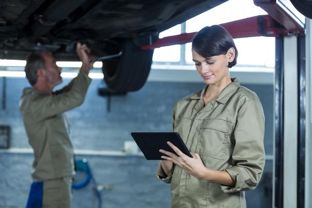 Female mechanic using digital tablet in repair shop