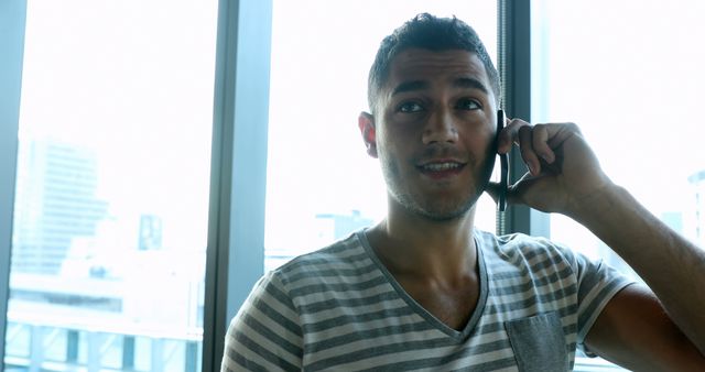 Man Smiling While Talking on Smartphone in Modern Office - Download Free Stock Images Pikwizard.com