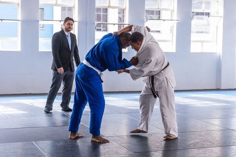 Marital Artists Grappling in Dojo During Competition Match