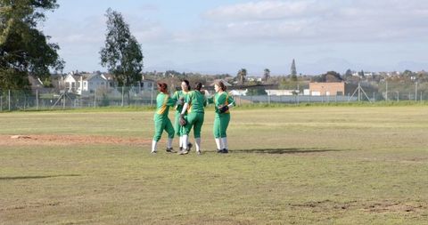 Female softball teammates celebrating victory on field