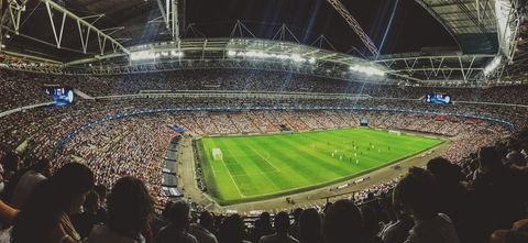 Panoramic Nighttime Stadium Hosting Intense Football Match under Floodlights