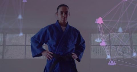 Female martial artist standing in blue gi with black belt and futuristic network overlay