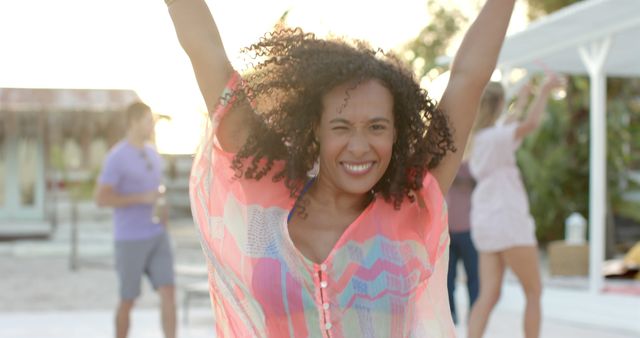 Joyful Young Woman Enjoying a Beach Party with Friends in Background - Download Free Stock Images Pikwizard.com