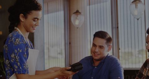Friendly Barista Providing Payment Service in Cozy Cafe