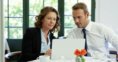 Business Colleagues Collaborating on Laptop at Restaurant