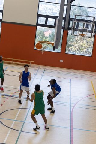 High School Basketball Players Competing on Indoor Court